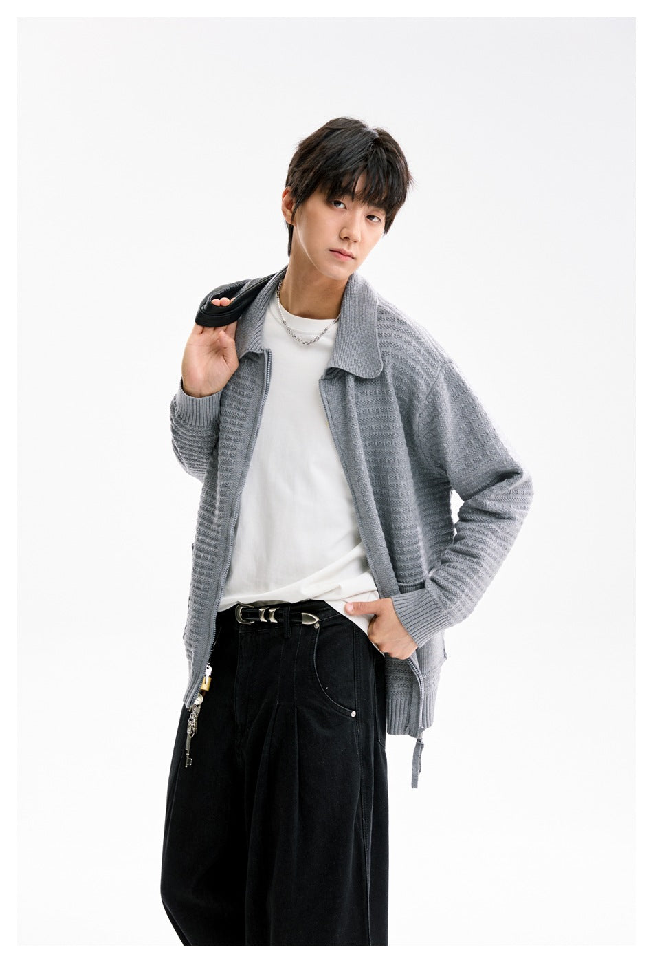 Close view of a model wearing a light gray textured collared cardigan over a white shirt.