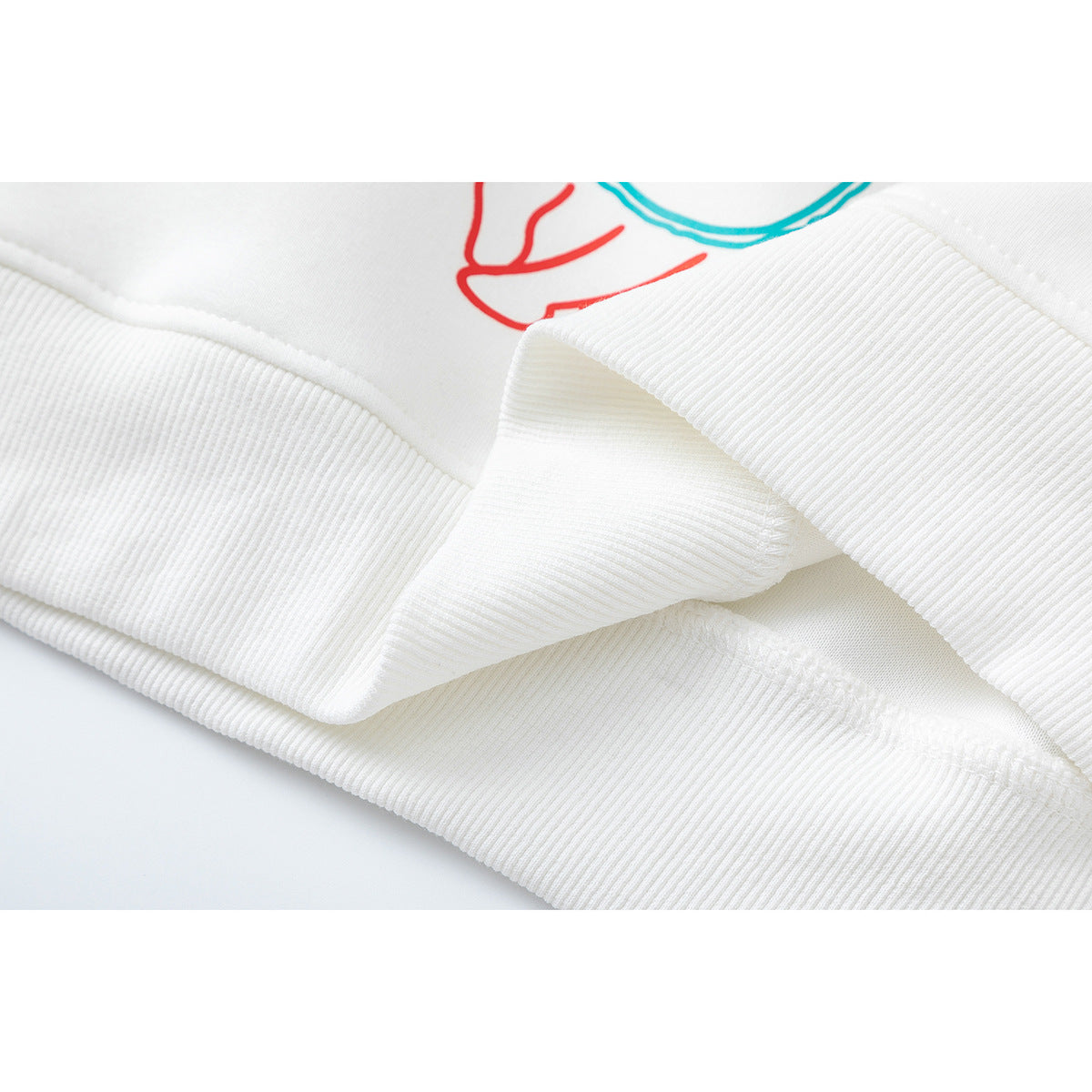 Close-up of a white sweatshirt's ribbed cuff and hem with visible stitching.