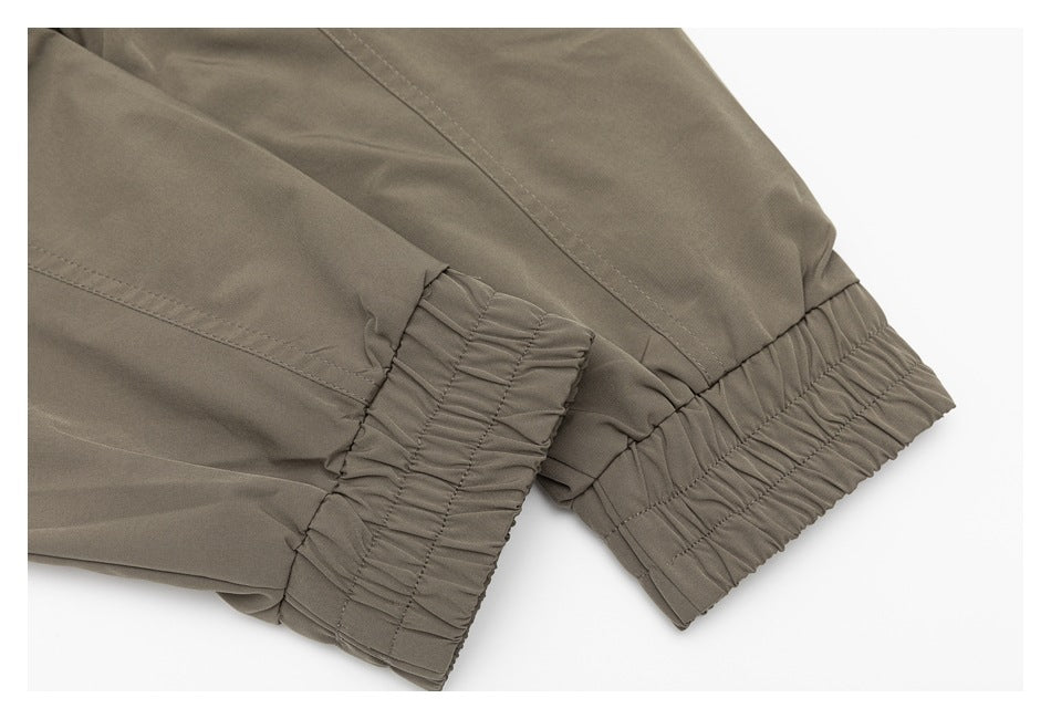 Close-up of the taupe jacket's gathered elastic sleeve cuffs and hem band.