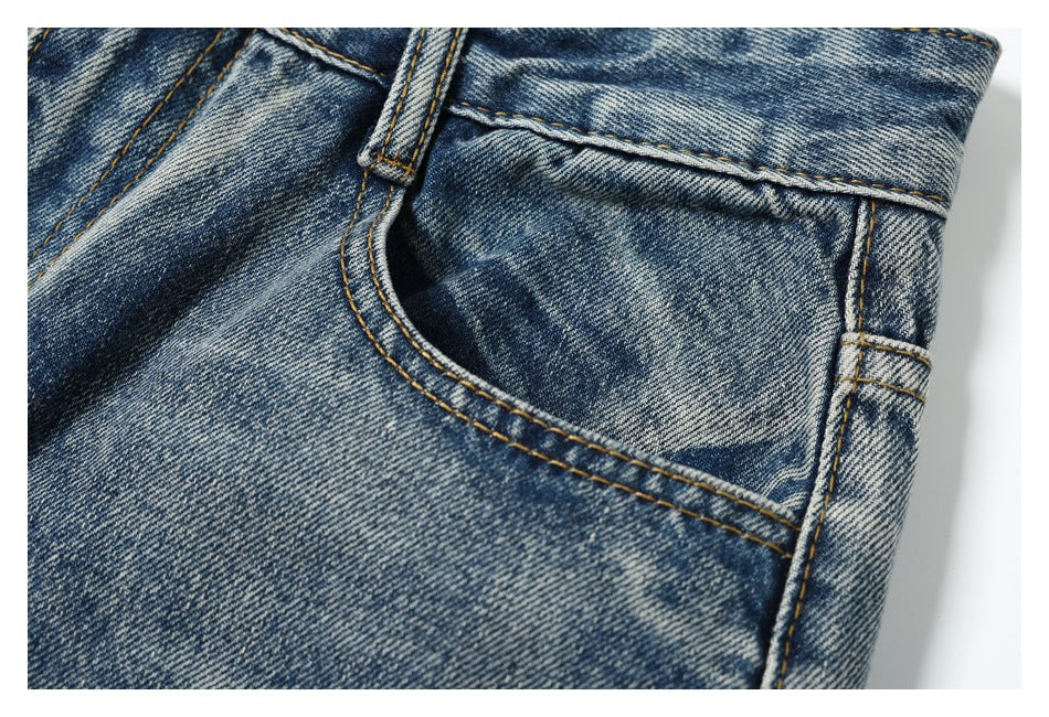 Close-up of a blue faded denim jeans front pocket, belt loop, and contrast stitching.