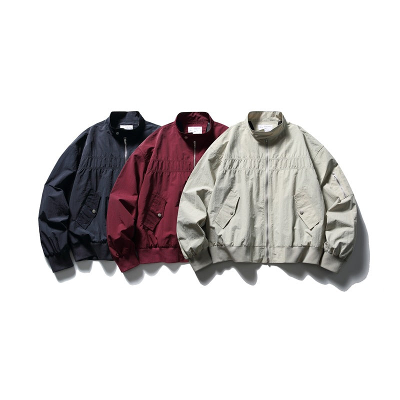 Three front-facing zip jackets arranged together in navy, burgundy and light gray-beige.