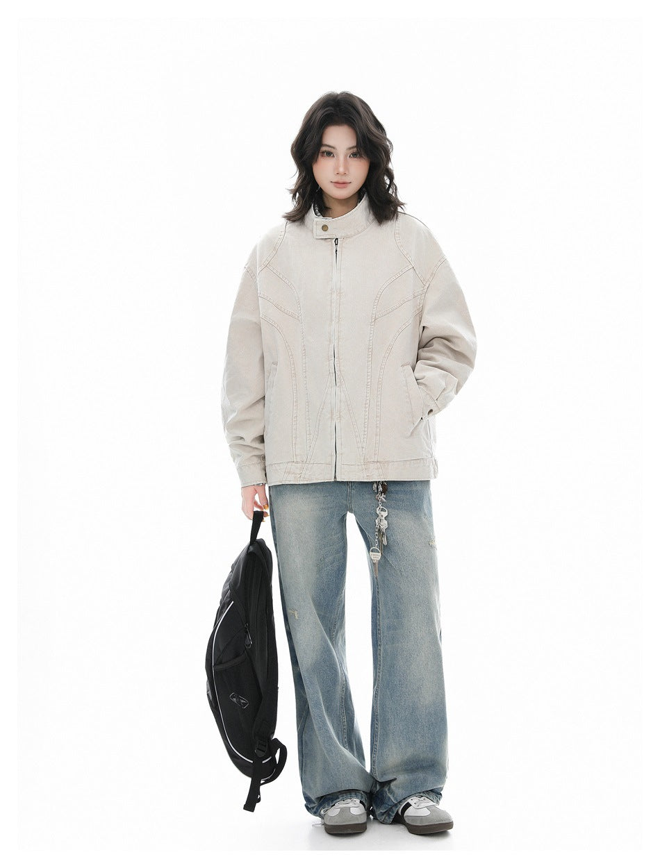 Full-length front view of a model wearing a light beige stand-collar jacket and loose blue jeans.