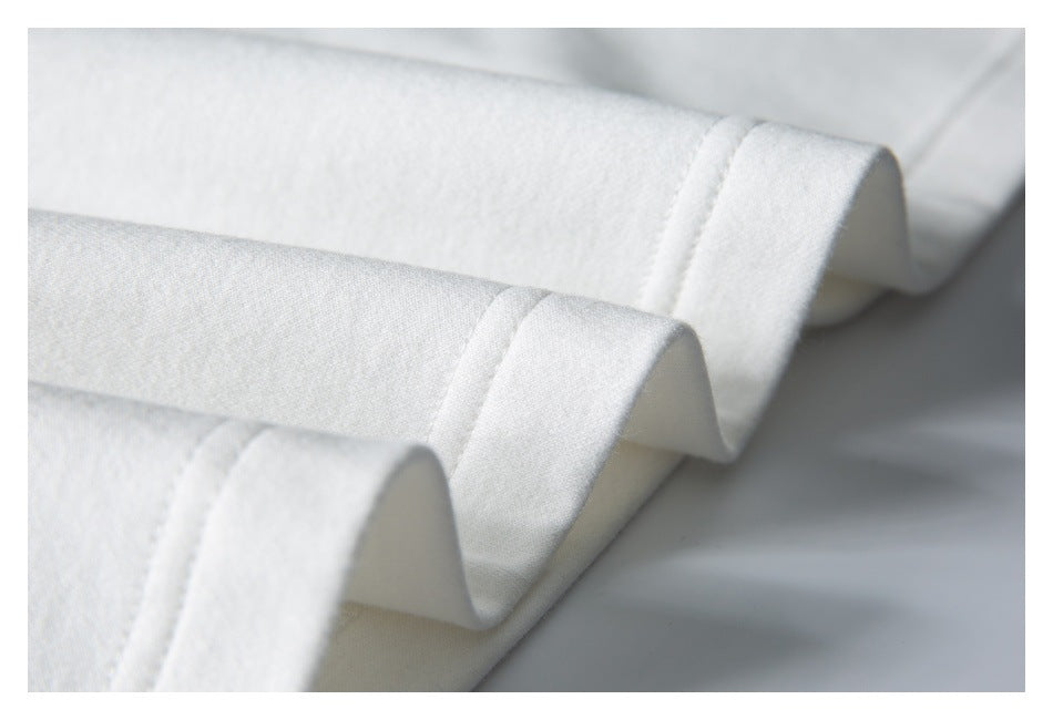 Close-up of folded white garment edges showing stitched hems.