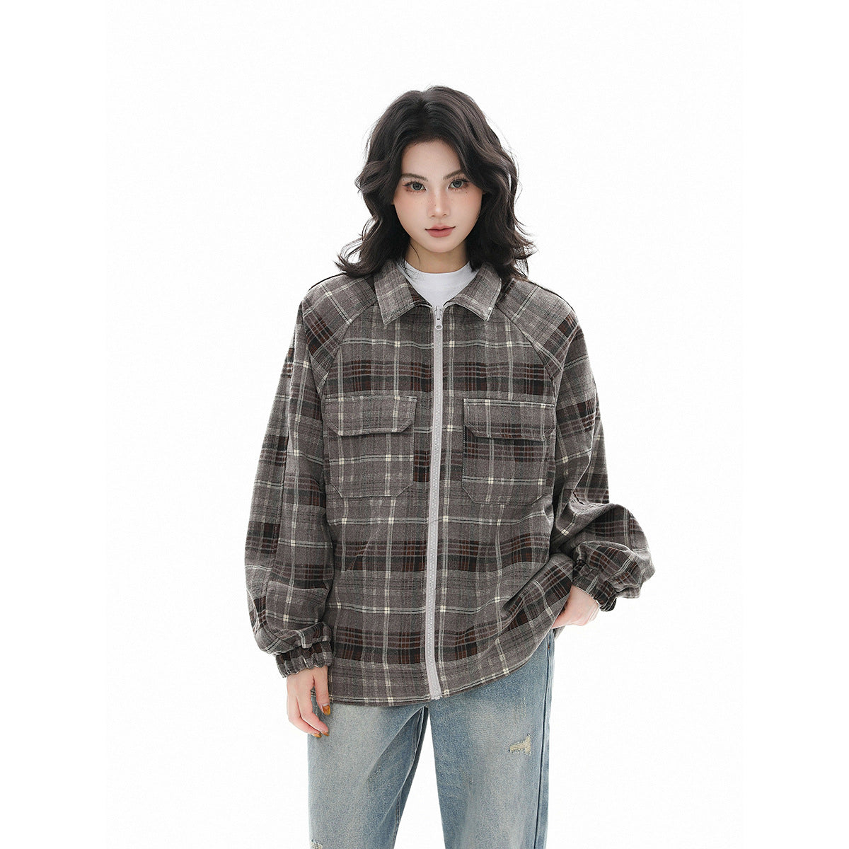 Model wearing an oversized gray and brown plaid zip-front jacket with a pointed collar and two flap chest pockets.