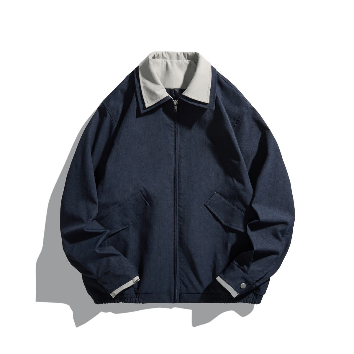 Navy zip-front collared jacket with light gray inner collar, flap pockets and elastic hem, flat lay