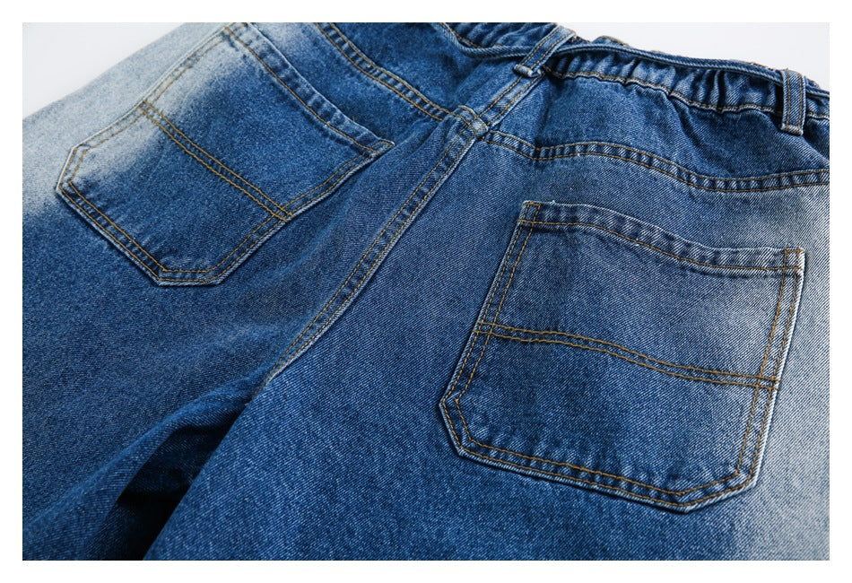 Close view of the back of blue jeans, showing two patch pockets and the waistband.