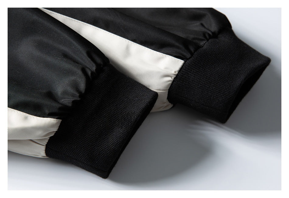 Close-up of black ribbed cuffs and beige panels on a black-and-beige garment.