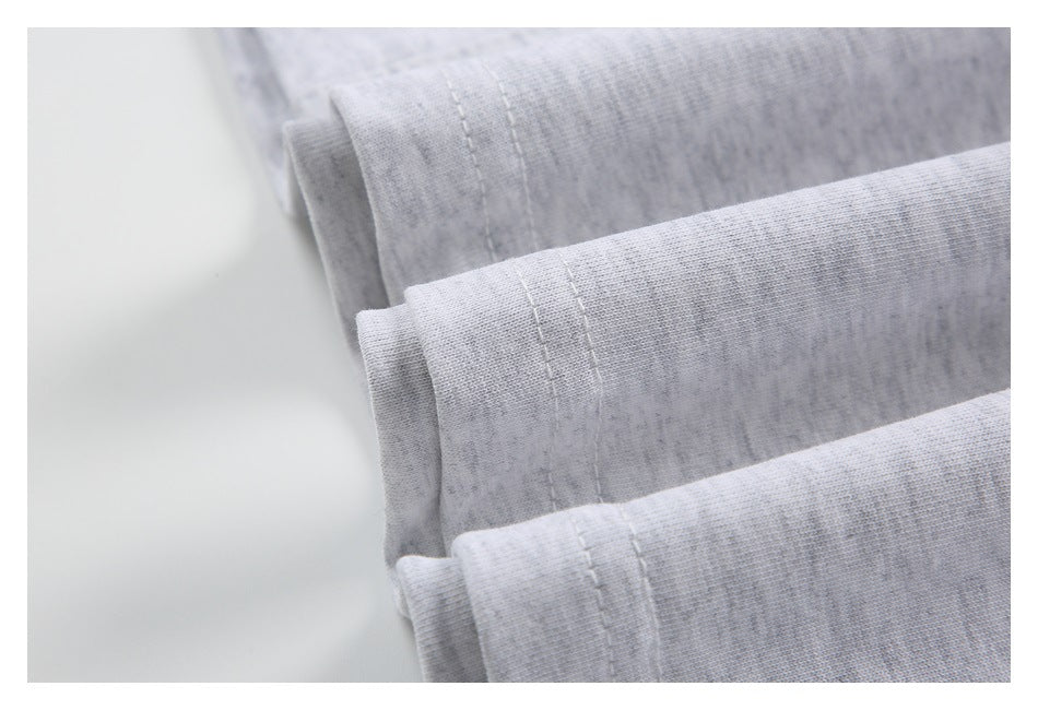 Close-up of folded edges and parallel stitching on light gray heathered fabric.