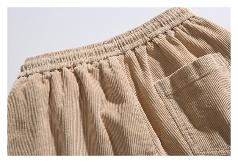 Close-up of the gathered waistband and a rectangular pocket on tan corduroy shorts.