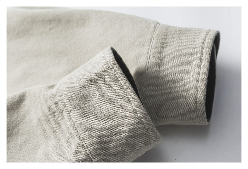 Close-up of a wide beige jacket cuff and folded sleeve showing the textured fabric.
