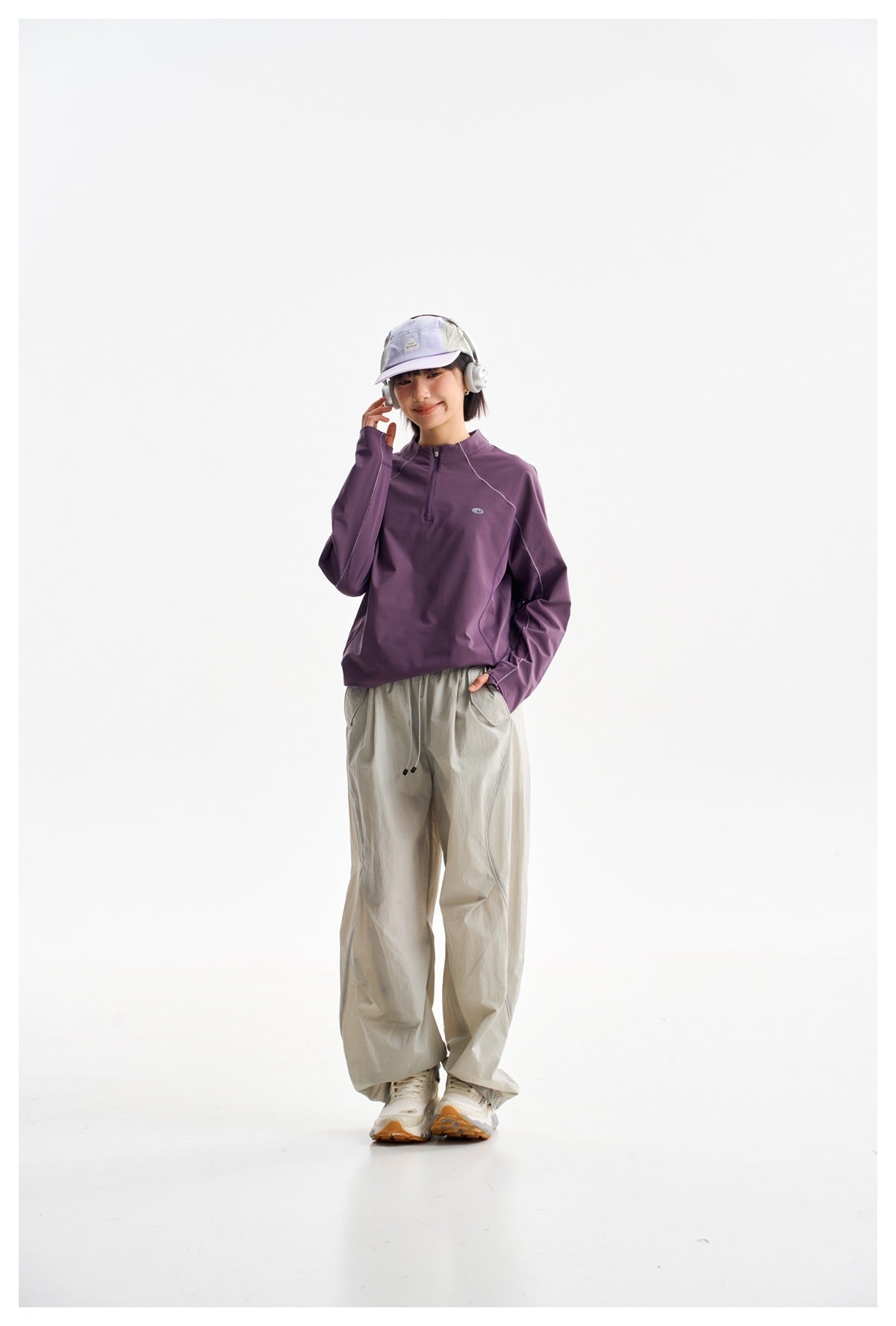 Model wearing a plum long-sleeve pullover with a short zip neckline and light-gray wide-leg pants.
