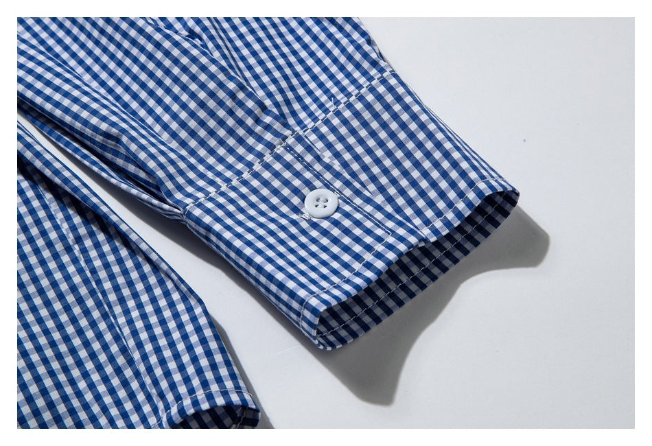 Close-up of a blue-and-white gingham shirt cuff with a white button and visible stitching.