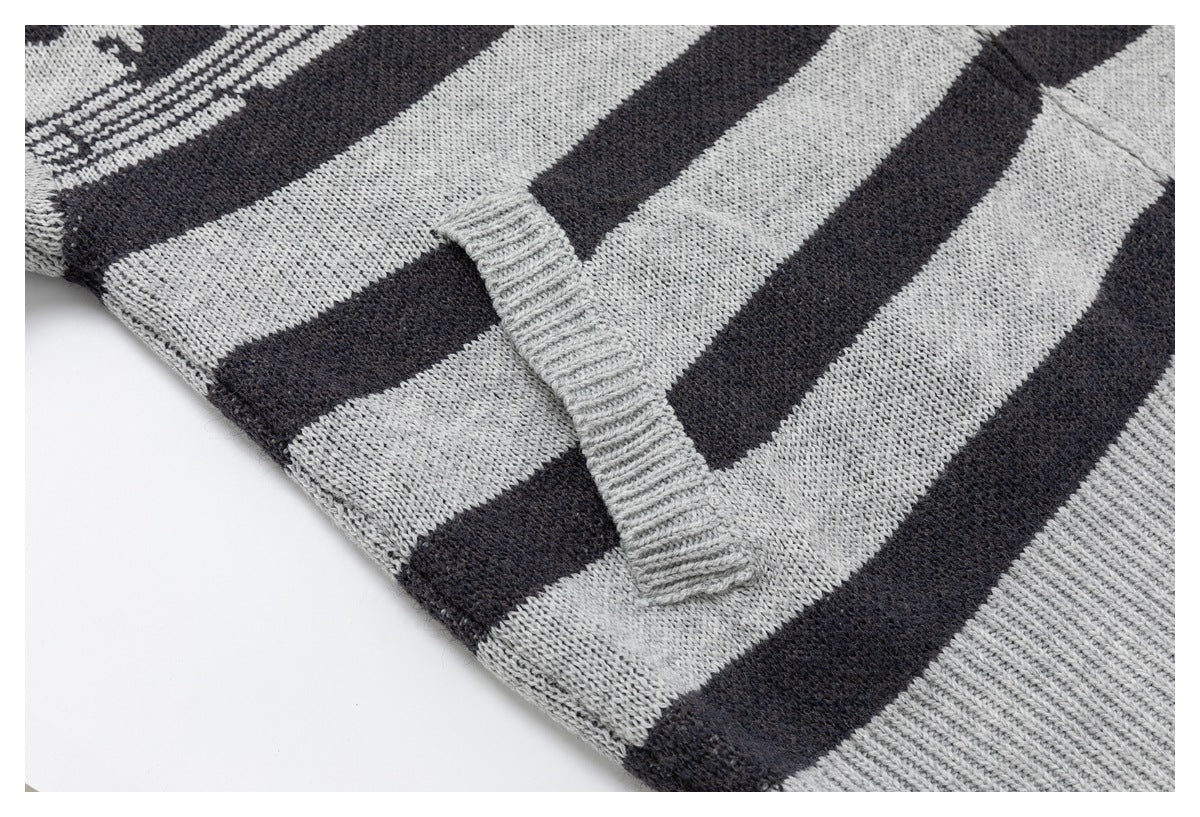 Close-up of a ribbed patch pocket on a gray-and-charcoal striped knit garment.