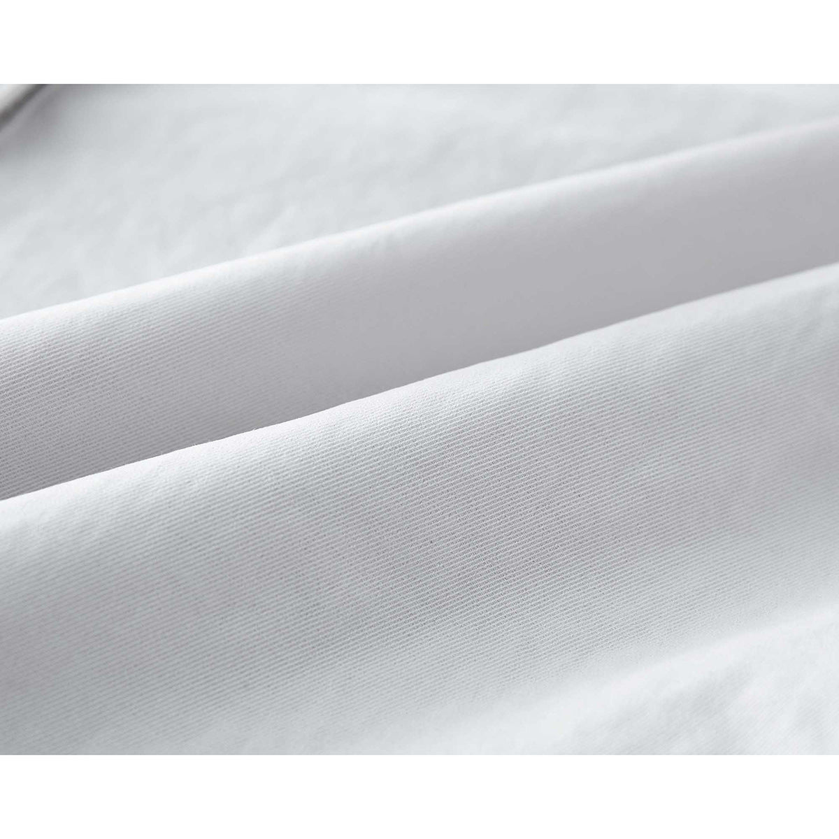 Extreme close-up of the fine diagonal weave and folds of white garment fabric.