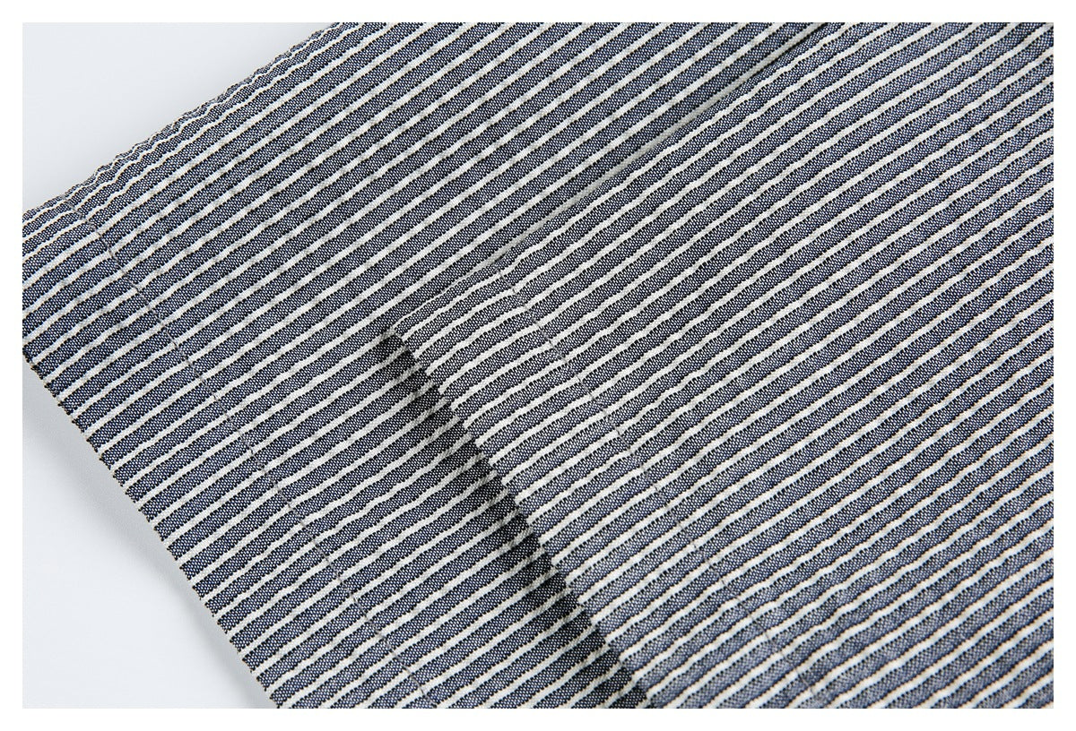 Close-up of navy and white striped garment fabric with a stitched seam and edge.
