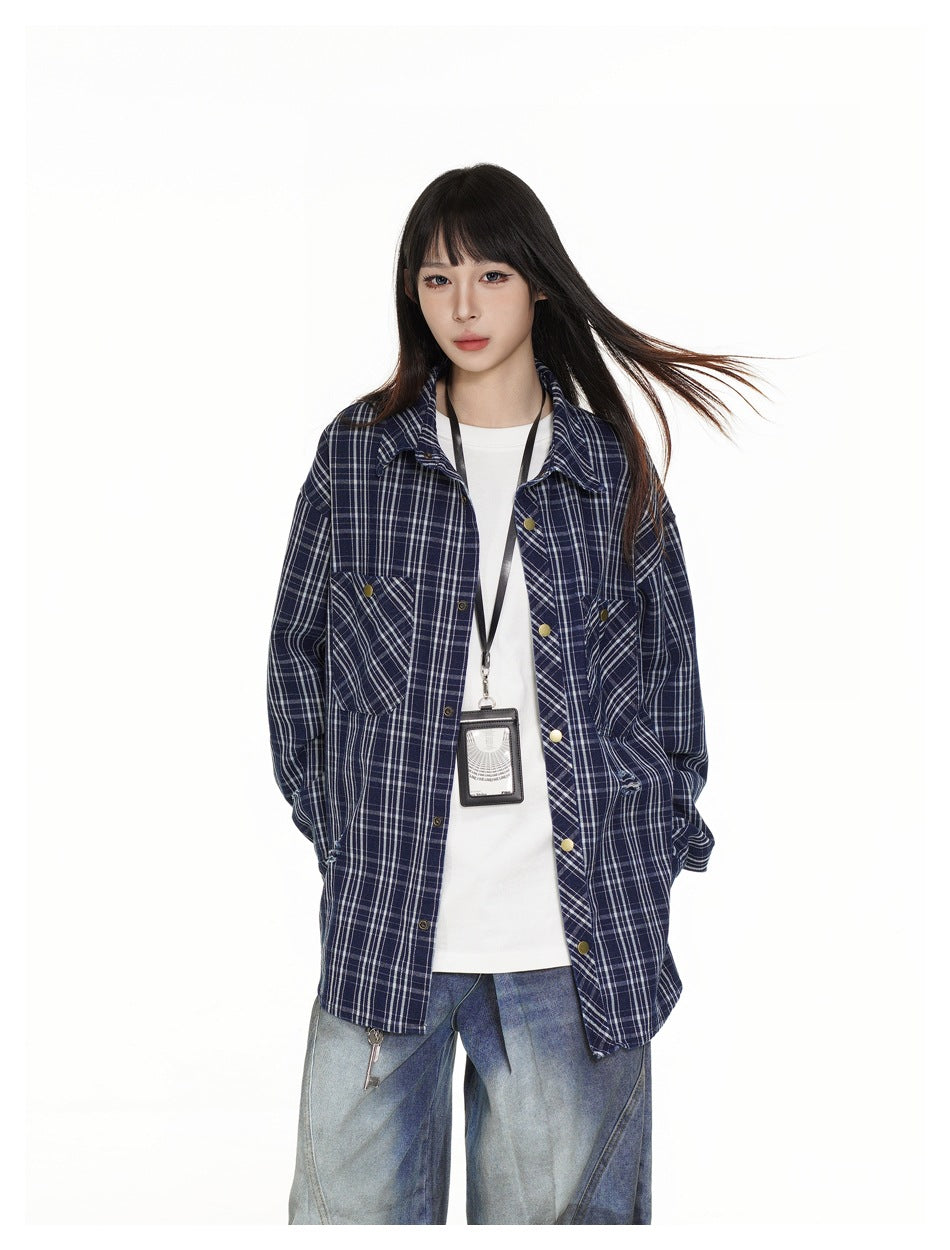 Model wearing an open navy plaid shirt over a white top, showing the shirt front, chest pockets and gold-tone buttons.