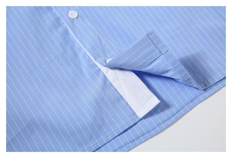 Close-up of a light blue pinstriped shirt with a folded edge revealing white inner facing.