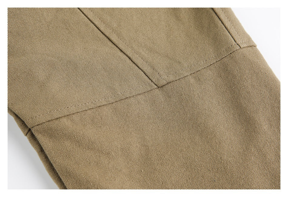 Close-up of khaki jacket fabric and intersecting stitched seams.