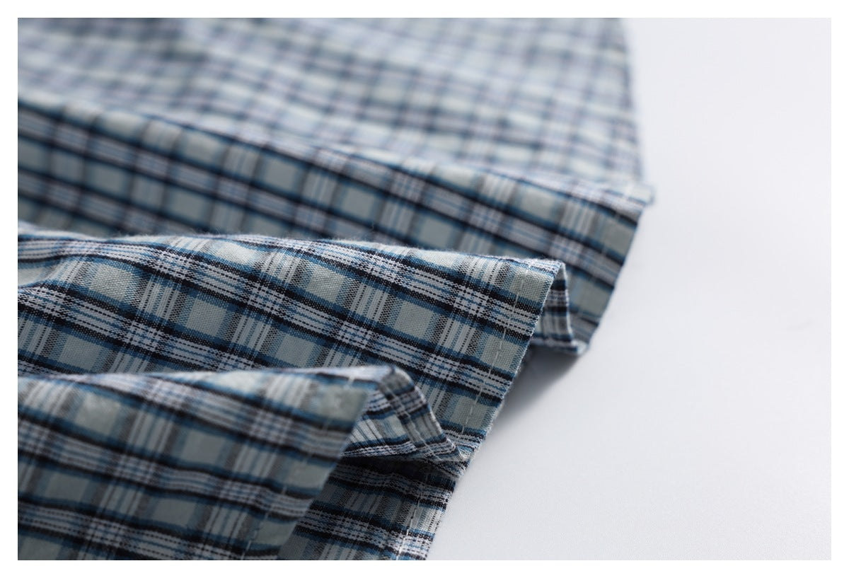 Close-up of layered edges and stitching on the blue plaid shirt.