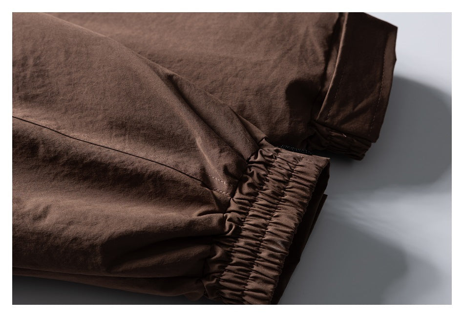 Close-up of a brown jacket sleeve ending in a gathered elastic cuff.