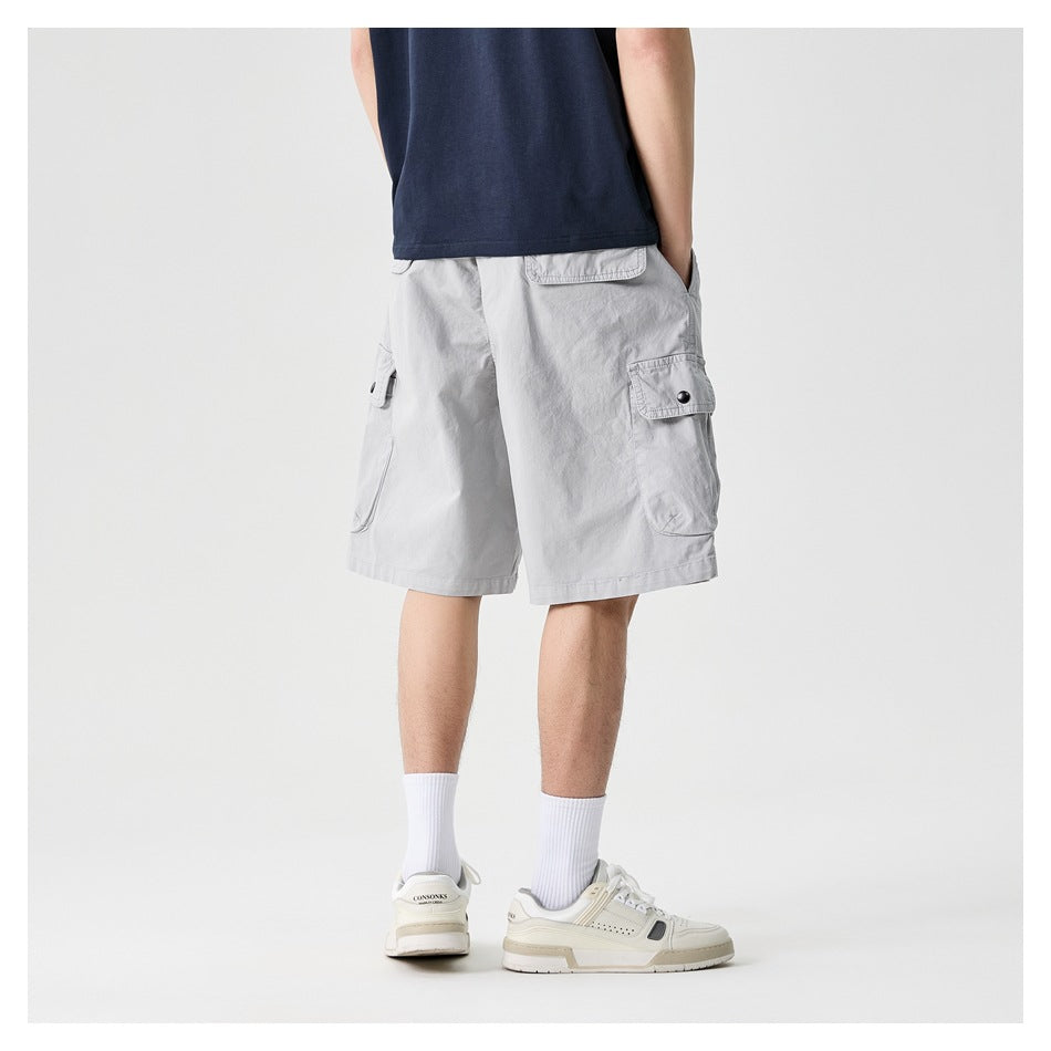 Back view of light gray cargo shorts with rear and side flap pockets, worn with a navy shirt.