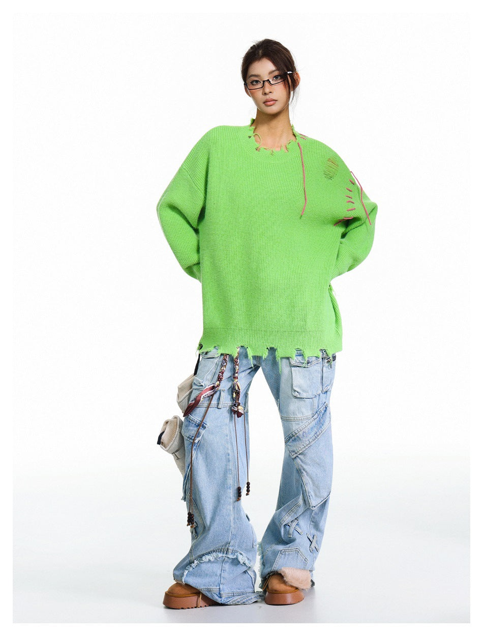 Model wearing an oversized lime-green sweater with a distressed neckline and hem, pink contrast stitching, and light-wash