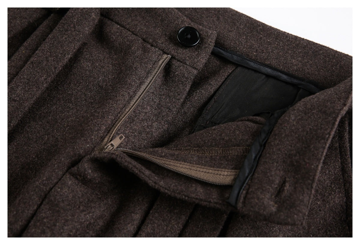 Close-up of dark brown trousers with the waistband open, showing the button, zipper fly, and lining.