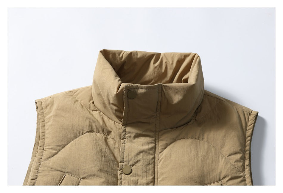 Close-up of the tan vest’s high collar, snap-front placket and upper quilted panels.