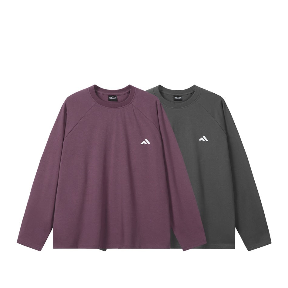 Two long-sleeve crew-neck tops shown from the front in plum and charcoal, each with a small white chest mark.