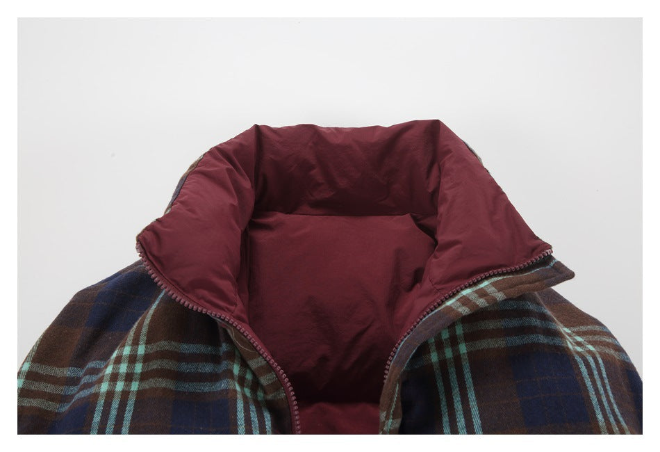 Close-up of an open jacket showing its burgundy inner collar and brown, navy, and teal plaid exterior.