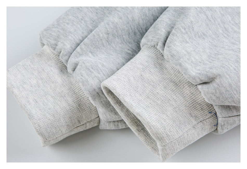 Close-up of light gray sleeves and wide ribbed cuffs folded together.