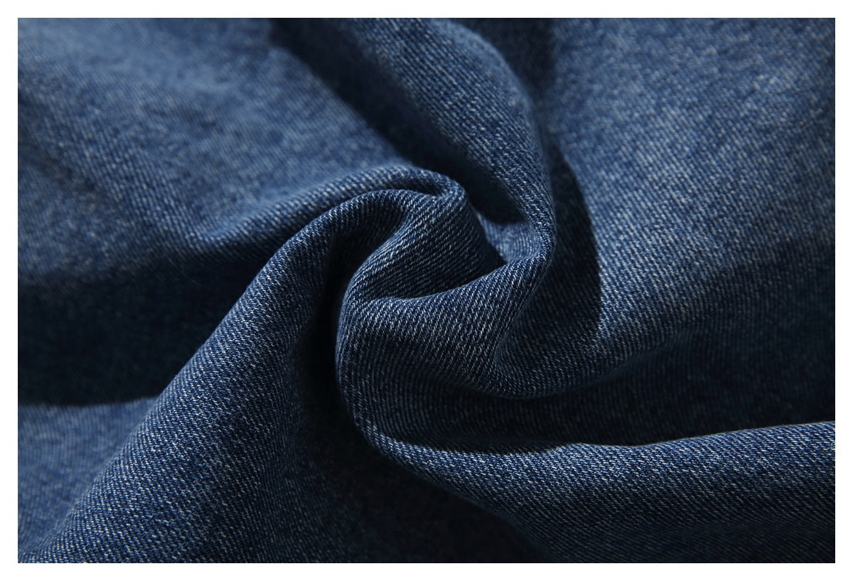 Macro view of dark blue denim fabric gathered into folds.