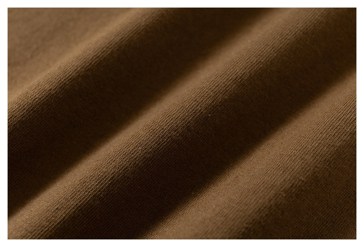 Macro view of brown knit fabric folds showing the fine surface texture.