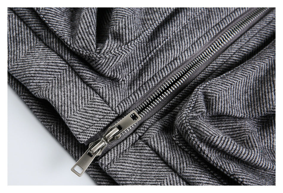 Close-up of a silver zipper on a gray herringbone jacket.