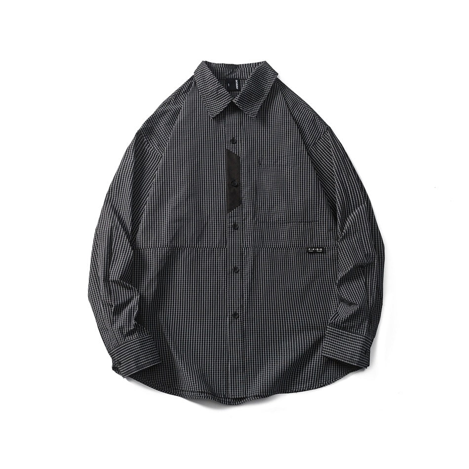Black and white fine grid check long-sleeve button shirt laid flat, with chest pocket and black contrast panel