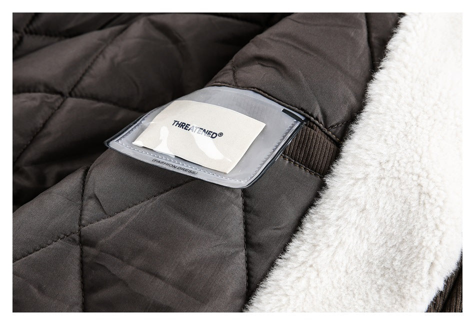 Close-up of a dark quilted garment lining, fuzzy white trim, and an interior label reading “THREATENED.”