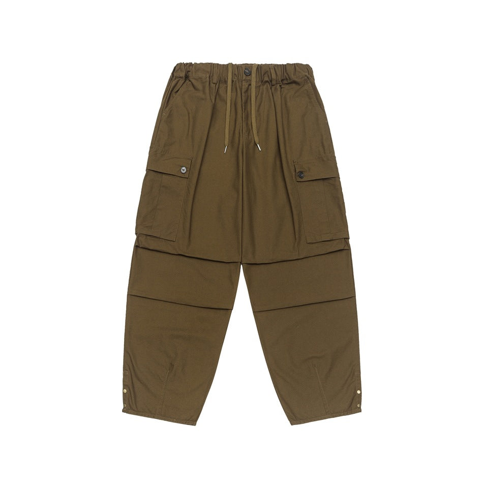 Brown wide-leg cargo pants with drawstring waist, button flap cargo pockets and snap hem details, flat front view