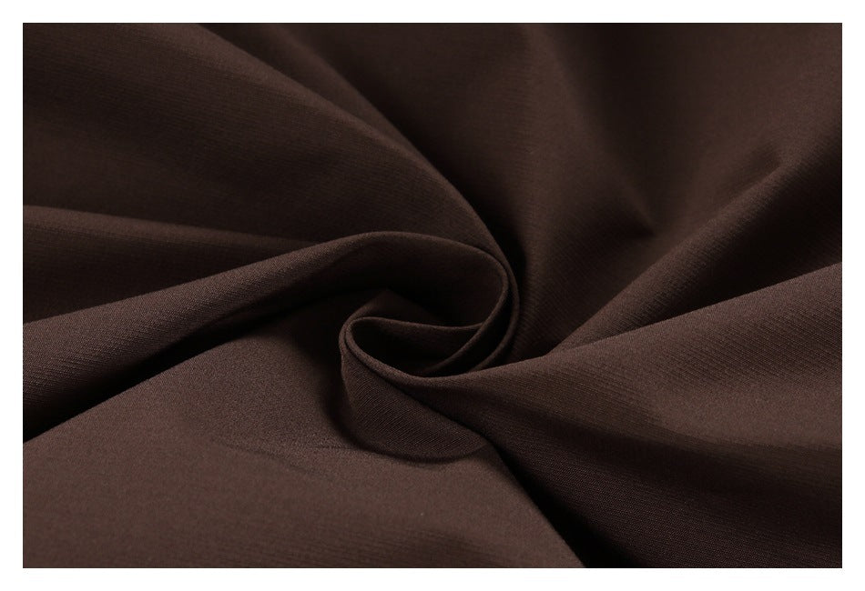 Close-up of dark brown fabric arranged in soft folds.