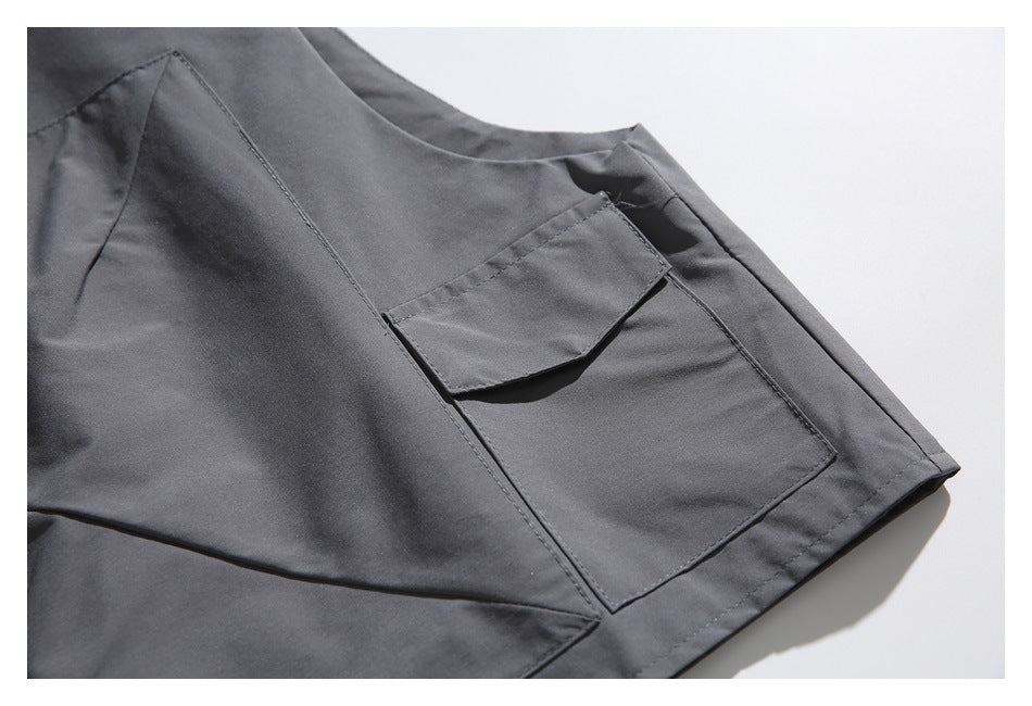 Close-up of a charcoal-gray jacket's rectangular flap pocket and stitched seams.