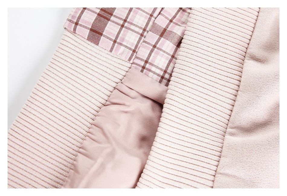 Close-up of pale blush-pink ribbed trim beside pink plaid lining and smooth fabric.