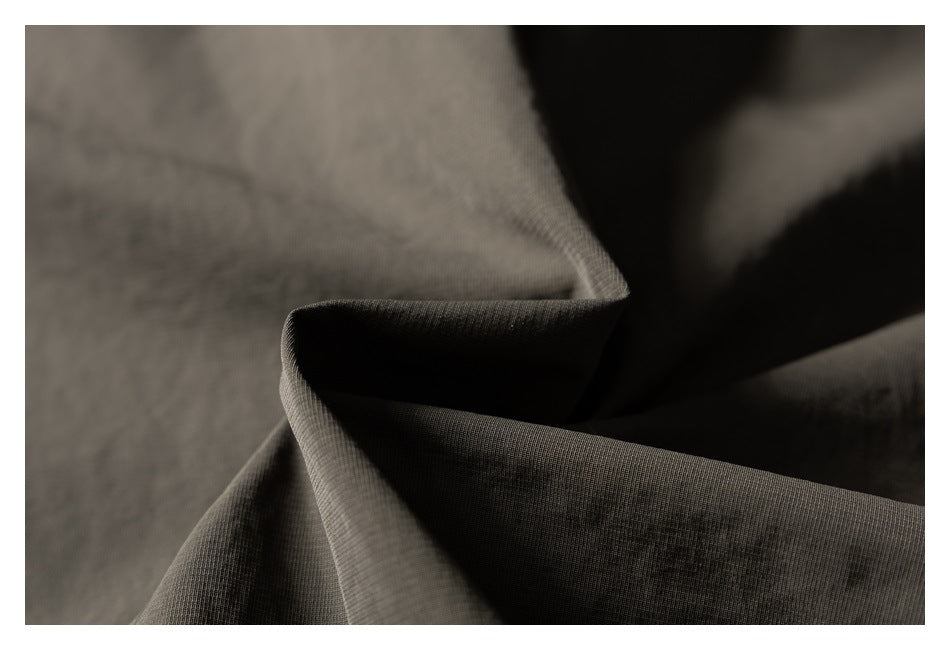 Close-up of olive jacket fabric folded to show its surface texture.