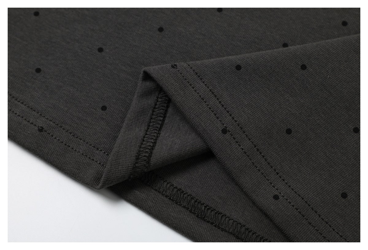 Close-up of the charcoal T-shirt's stitched hem and overlocked inside seam, with a black dot print.