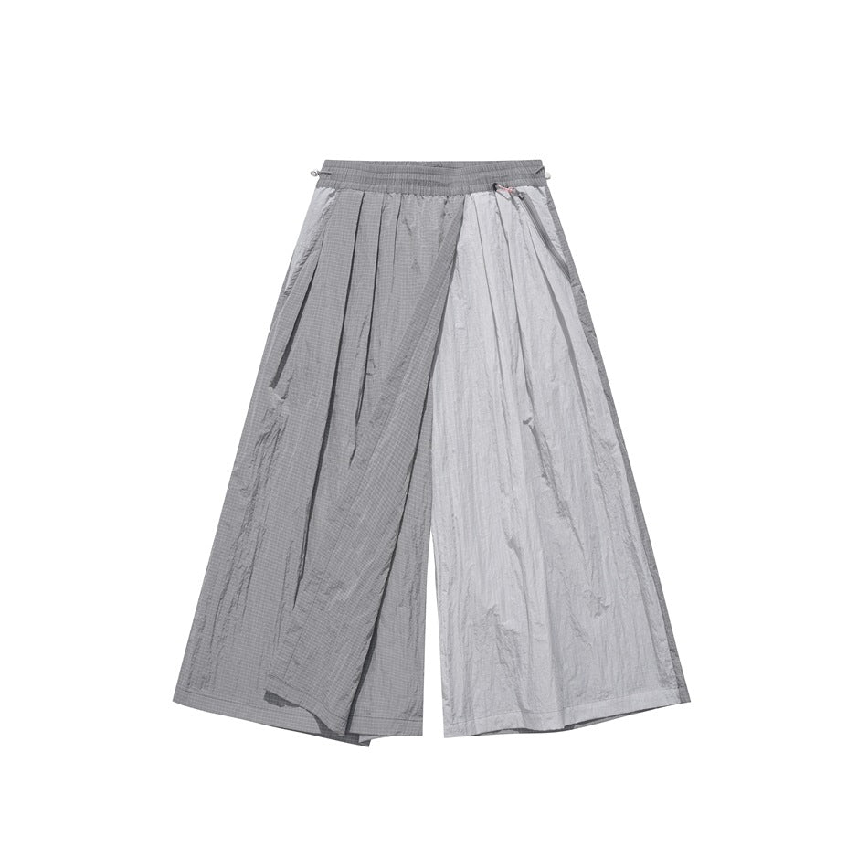 Front view of two-tone gray wide-leg pants with an elastic waistband, layered panels and a zip pocket with pink pull cord.