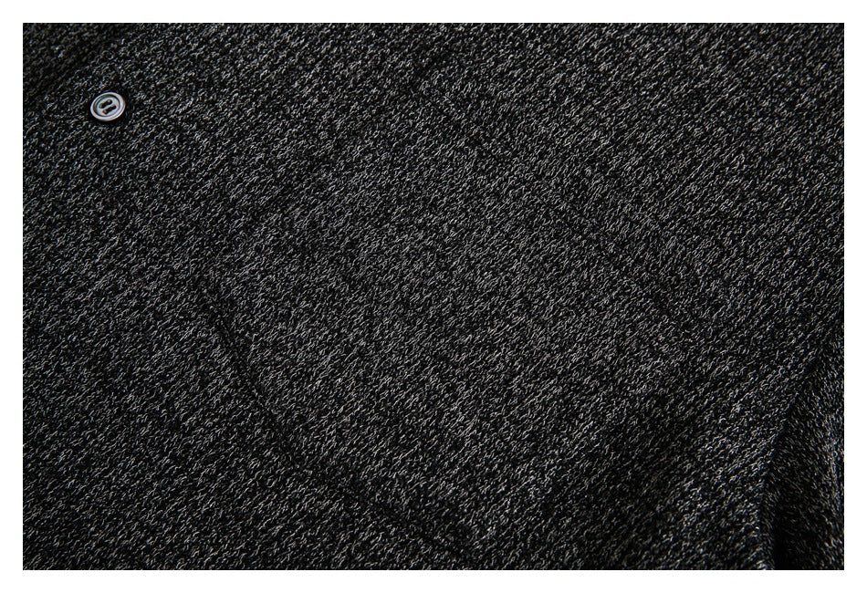 Close-up of a small button on dark charcoal knit fabric with light gray flecks.
