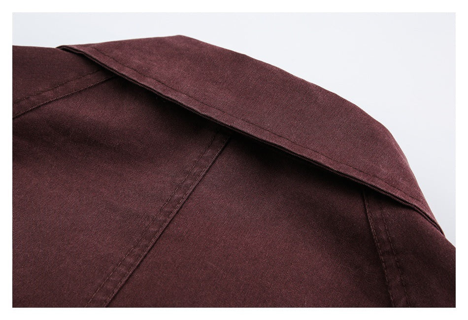 Close-up of a burgundy garment's collar-like flap and shoulder seams.