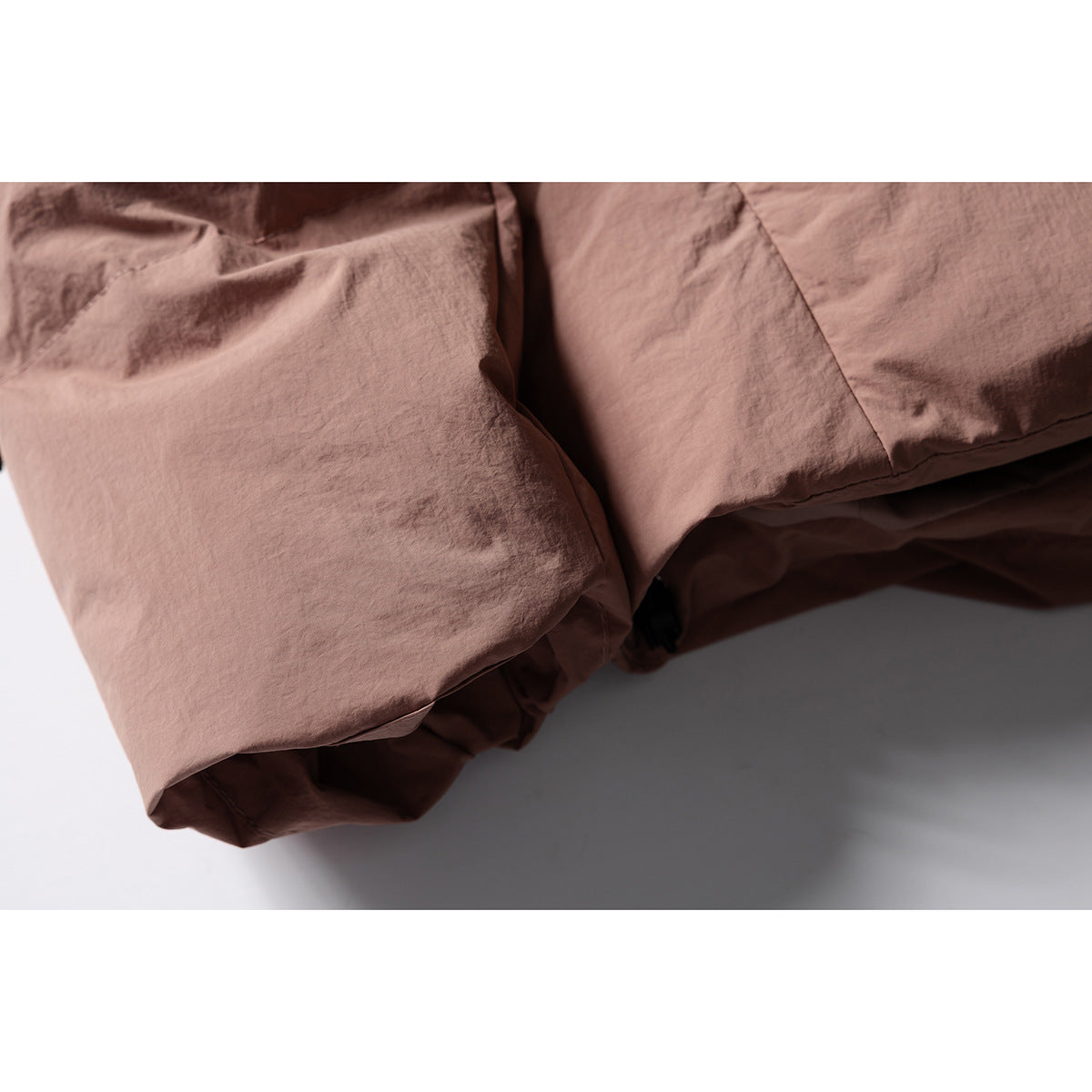 Close-up of the crinkled dusty rose jacket fabric and stitched panel seams.