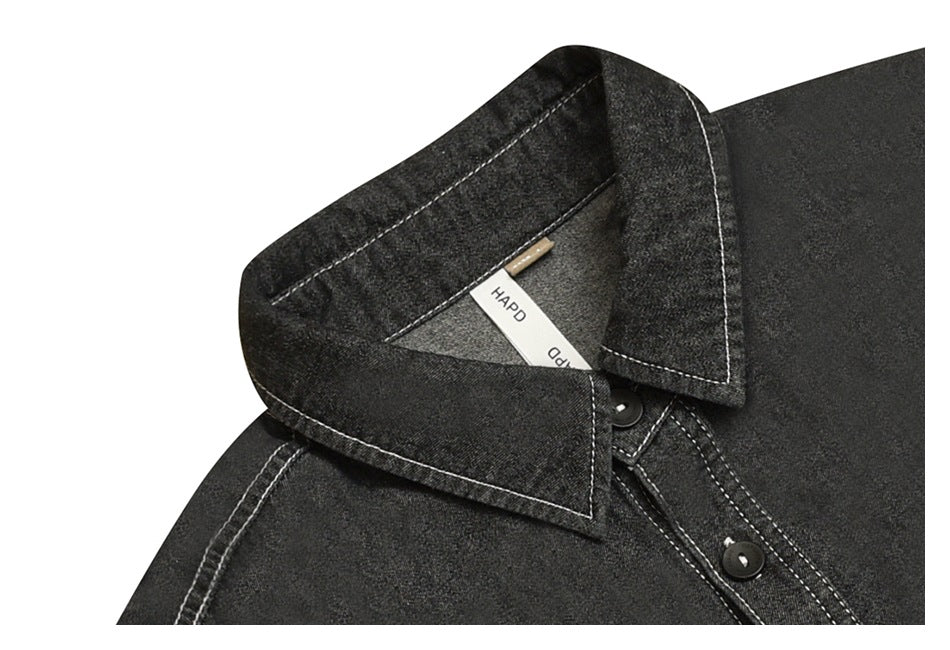 Close-up of a charcoal shirt collar and placket with dark buttons and contrasting stitching.