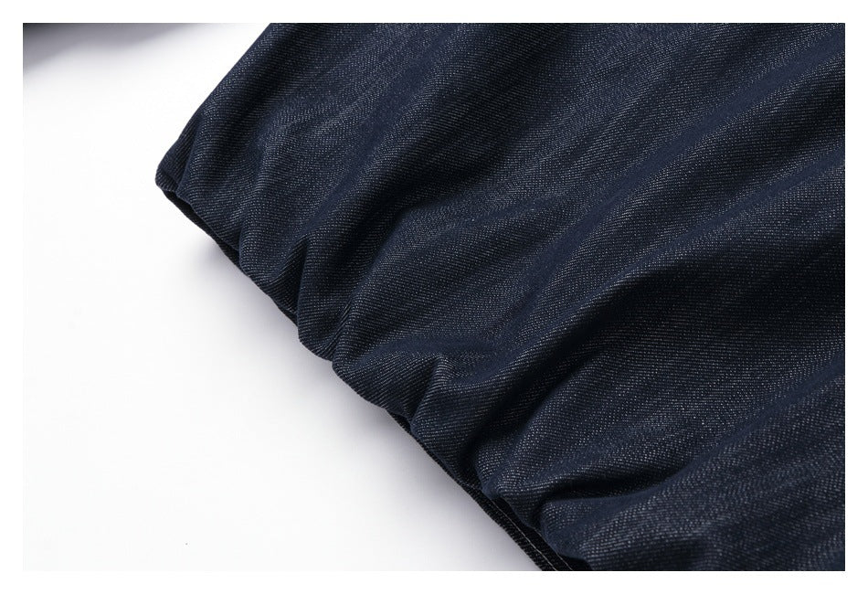 Close-up of folded dark indigo denim fabric with a fine diagonal weave.