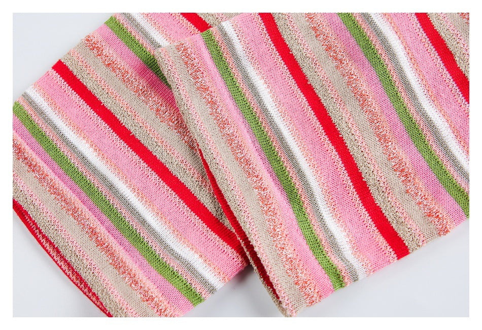 Close-up of folded striped knit fabric showing a finished edge in pink, red, green, white, and beige.