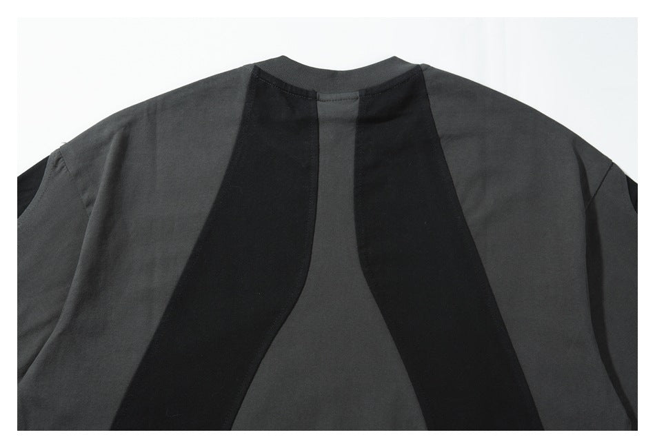 Back view of a charcoal and black color-block shirt with curved vertical panels and a crew neckline.